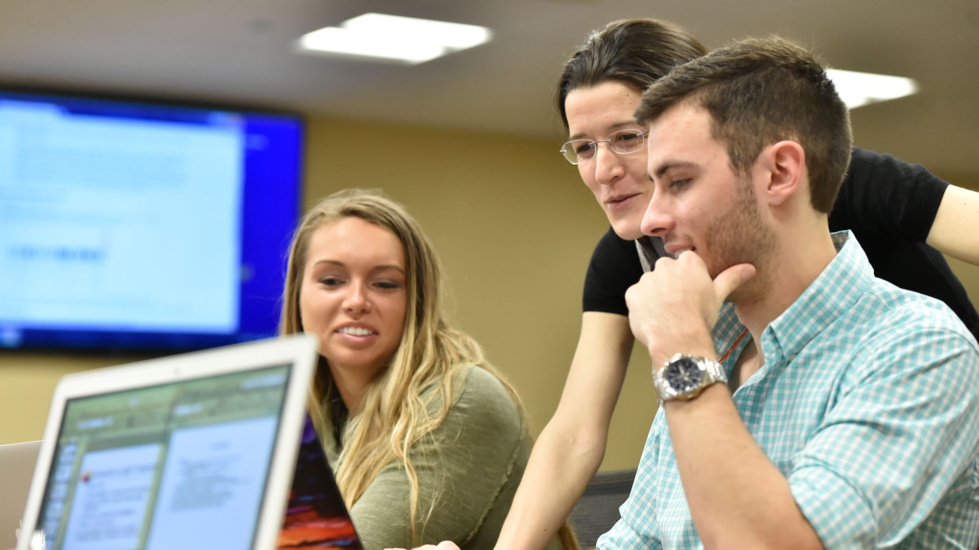 Professor in a classroom teaching students in a hands on setting.