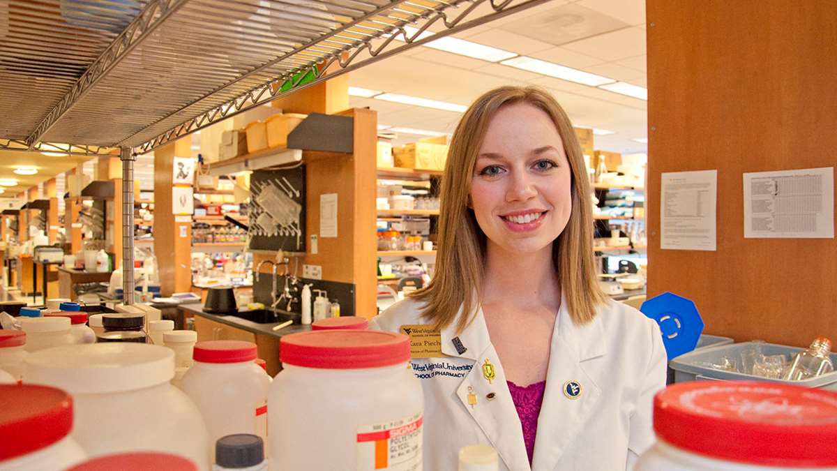 Kara Piechowski in a pharmaceutical lab in her white coat