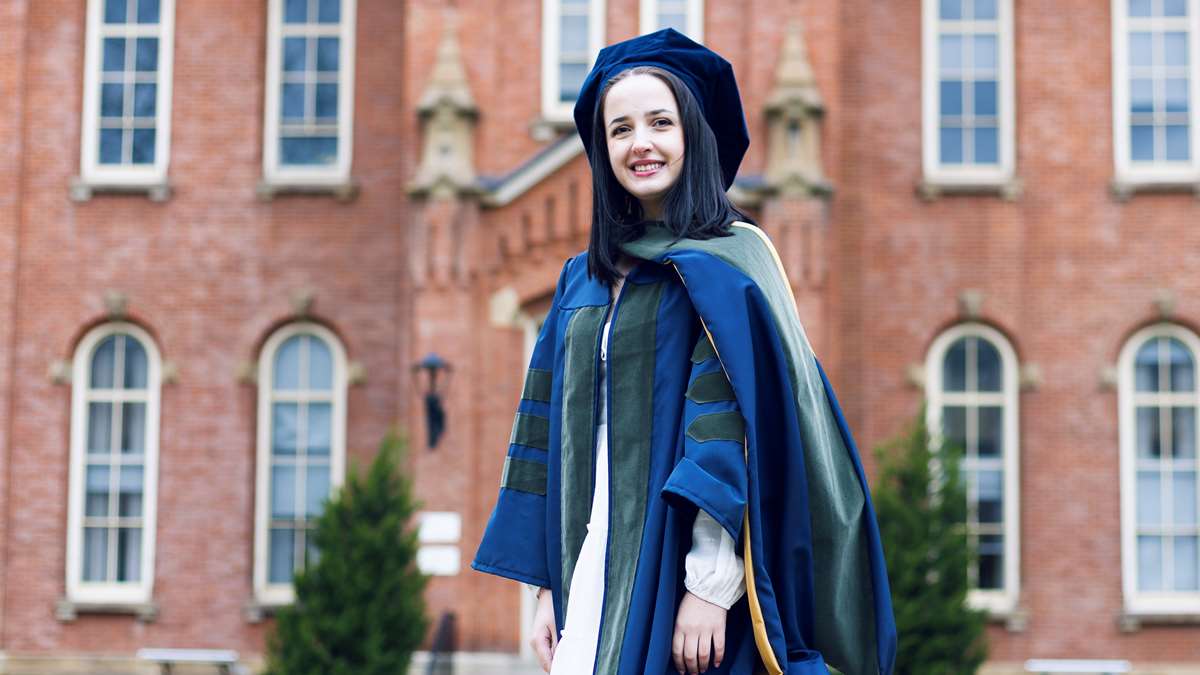 PharmD Candidate Marianna Kibak stands in Woodburn Circle in her regalia.