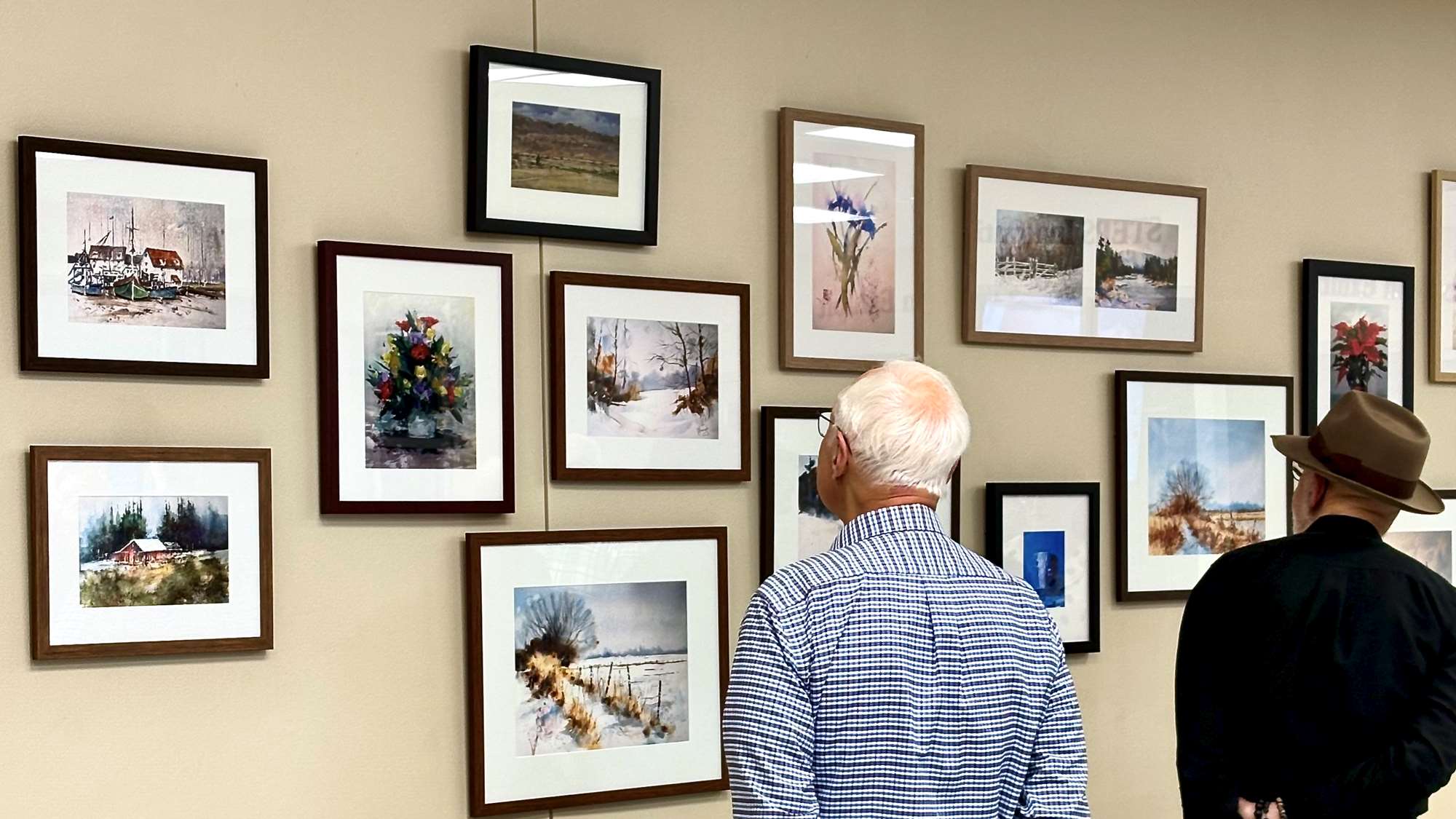 Two males looking at an art exhibit.