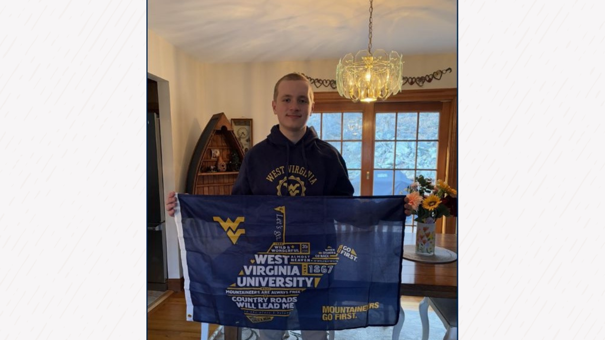A male student holding a WVU flag.